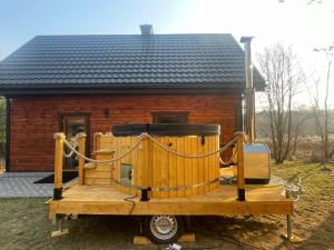 a small wooden cabin with a chain around it at Domek na Zagórze - domek całoroczny in Krasnobród