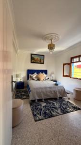 a bedroom with a bed and a chandelier at Résidence chez Said in Sidi Ifni