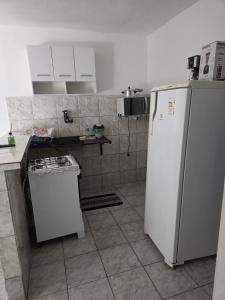a kitchen with a white refrigerator and a counter at Casa com 2 Quartos e Garagem, Alto da Cruz, Camaçari in Camaçari +3 photos