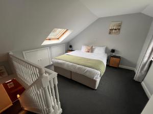 a small bedroom with a bed and a stair case at Pendle Inn in Barrowford