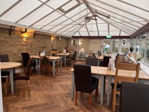 a dining room with wooden tables and chairs at Pendle Inn in Barrowford