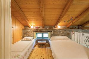 two beds in a room with a wooden ceiling at villapetramarina in Tsakaíoi