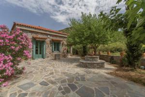a stone patio in front of a house at villapetramarina in Tsakaíoi