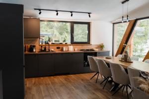 eine Küche und ein Esszimmer mit Tisch und Stühlen in der Unterkunft Arenis in Muntele Băişorii