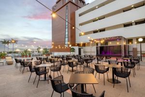 a restaurant with tables and chairs in front of a building at AluaSoul Costa Adeje - Adults Only in Adeje