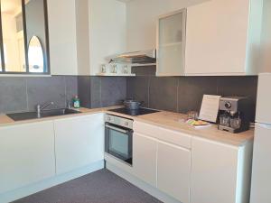 a kitchen with white cabinets and a sink at Le Loft - En Plein Centre Très Spacieux in Beauvais