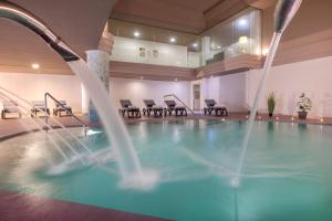 a swimming pool in a hotel room with chairs at AluaSoul Costa Adeje - Adults Only in Adeje