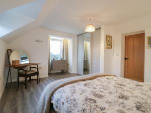 a bedroom with a bed and a desk and a mirror at The Kiln in Bolnhurst