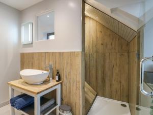 a bathroom with wood paneling and a sink at The Kiln in Bolnhurst +17 photos