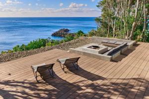two chairs on a wooden deck with the ocean at UMIBE Terrace in Shima