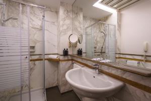 a bathroom with a sink and a glass shower at Exe Majestic in Naples +60 photos