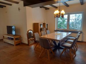 a dining room with a table and chairs and a television at Ferienhaus Schünhoff in Schneverdingen