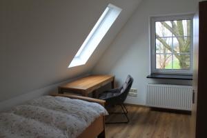 a bedroom with a bed and a desk and a window at Ferienhaus Schünhoff in Schneverdingen