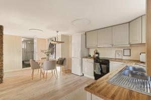 a kitchen with white cabinets and a table and chairs at Aurora Bliss - Waterfront Jacuzzi & Sauna near Bergen in Askøy