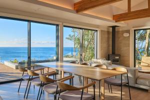 a dining room with a table and chairs and the ocean at UMIBE Terrace in Shima