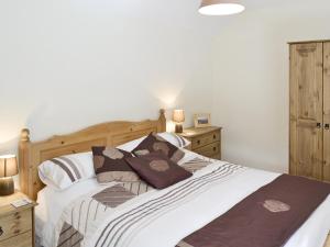 a bedroom with a large bed with pillows on it at Jeremiah Cottage in Bradwell