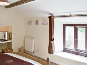 a bedroom with a bed and a window at Jeremiah Cottage in Bradwell
