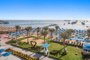 a view of a beach with palm trees and umbrellas at Pickalbatros Blu Spa Resort - Adults Friendly 16 Years Plus- Ultra All-Inclusive in Hurghada