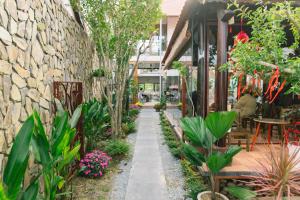 a garden with plants and a stone wall at Berry Boutique in Hue