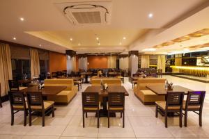 a restaurant with couches and tables and chairs at The White Pearl Suites in Bangalore