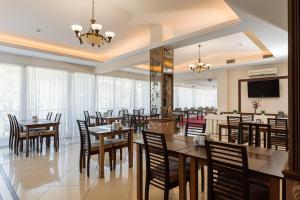 a restaurant with tables and chairs and a flat screen tv at Курортний комплекс Santa Maria in Skhidnitsa