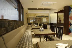 a restaurant with tables and chairs in a restaurant at The White Pearl Suites in Bangalore +14 photos