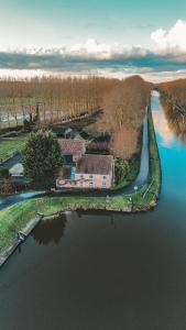 an aerial view of a house on an island in the water at B&B Hoeve Westdijk in Oostkamp +34 photos