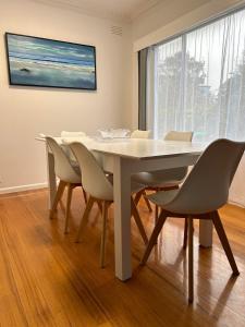 a dining room with a white table and chairs at Genesta House in Cowes