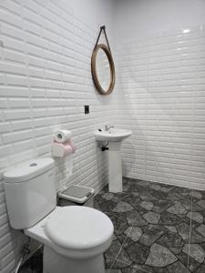 a white bathroom with a toilet and a sink at Rice Terrace Bungalows in Tetebatu +60 photos