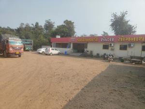 a gas station with cars parked in front of it at kathiyawadi Hotel somnath in Kevdi Road