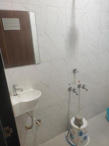 a white bathroom with a sink and a mirror at kathiyawadi Hotel somnath in Kevdi Road