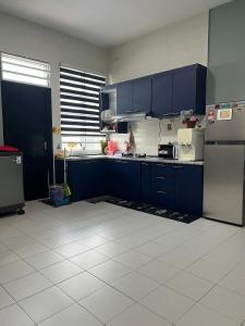 a kitchen with blue cabinets and a refrigerator at Teratak Amaris Homestay MELAYU ONLY in Sungai Petani