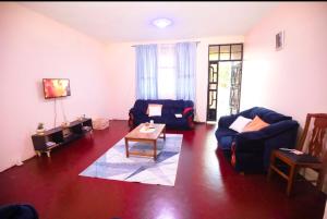 a living room with two blue couches and a table at New Star House in Arusha