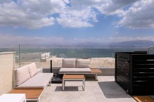 a balcony with a couch and a table and a view at וילה לה מר - וילה עם בריכה ו-3 סוויטות מדהימות עם נוף לים המלח in Neve Zohar