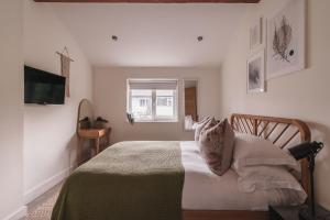 a bedroom with a bed with white sheets and a window at Stylish accommodation - Bowness centre with parking space in Bowness-on-Windermere