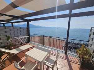 a balcony with a table and chairs and the ocean at Casa Rossa 1888 in Torre del Greco