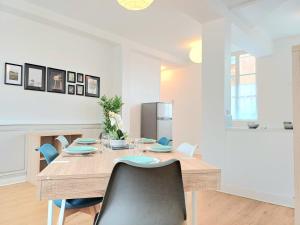 a dining room with a wooden table and chairs at Le Commercy - En Hyper Centre Et Très Spacieux in Beauvais