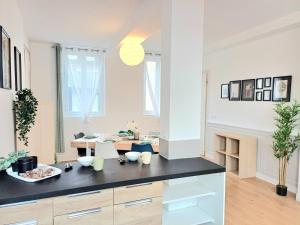 a kitchen with white walls and a black counter top at Le Commercy - En Hyper Centre Et Très Spacieux in Beauvais +16 photos