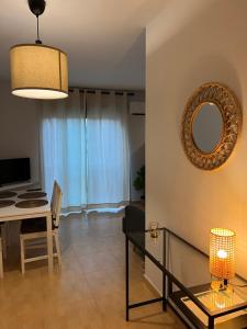 a living room with a table and a mirror at Rincón Costero in Rincón de la Victoria