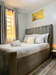 a bedroom with a large bed with a large headboard at Graphite & Gold Suite in Ruiru +22 photos
