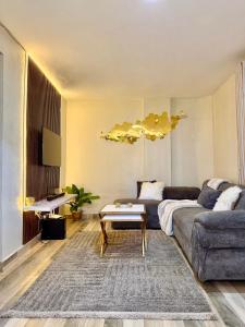 a living room with a couch and a table at Graphite & Gold Suite in Ruiru