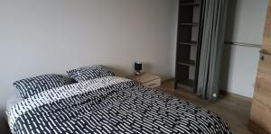 a bedroom with a bed with two pillows and a refrigerator at Gite du Châtelard in Thiébouhans