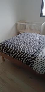 a bed with a blue and white comforter on it at Gite du Châtelard in Thiébouhans