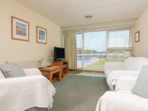 a bedroom with two beds and a tv and a window at 3 The Salcombe in Salcombe