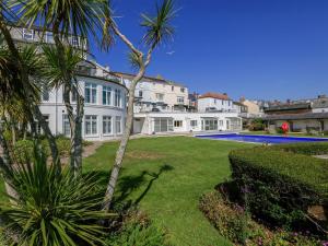 a large white mansion with a palm tree and a yard at 3 The Salcombe in Salcombe