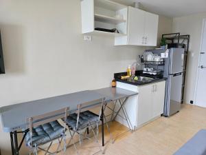 a kitchen with a table and chairs and a refrigerator at SM Cebu City Sunvida Tower Condominium in Cebu City