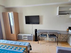 a living room with a table and a tv on the wall at SM Cebu City Sunvida Tower Condominium in Cebu City +8 photos