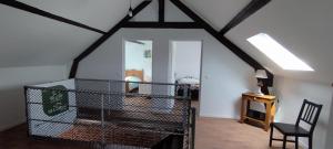 a attic room with a black chair and a window at Gîte Le Lyséas 6 personnes proche Forêt de Mormal & Animaux bienvenus in Bousies