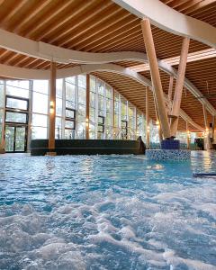 an indoor swimming pool with blue water in a building at Hotel Sole Felsen Welt in Gmünd
