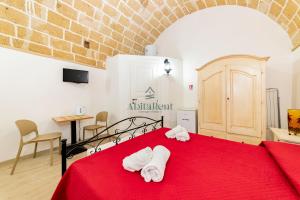 a bedroom with a red bed with towels on it at Casa di Ponente - Gallipoli in Gallipoli +3 photos